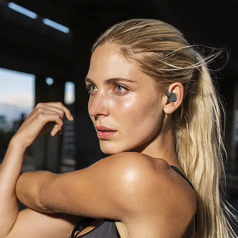 Woman with a fitness tracker on her ear in a gym setting